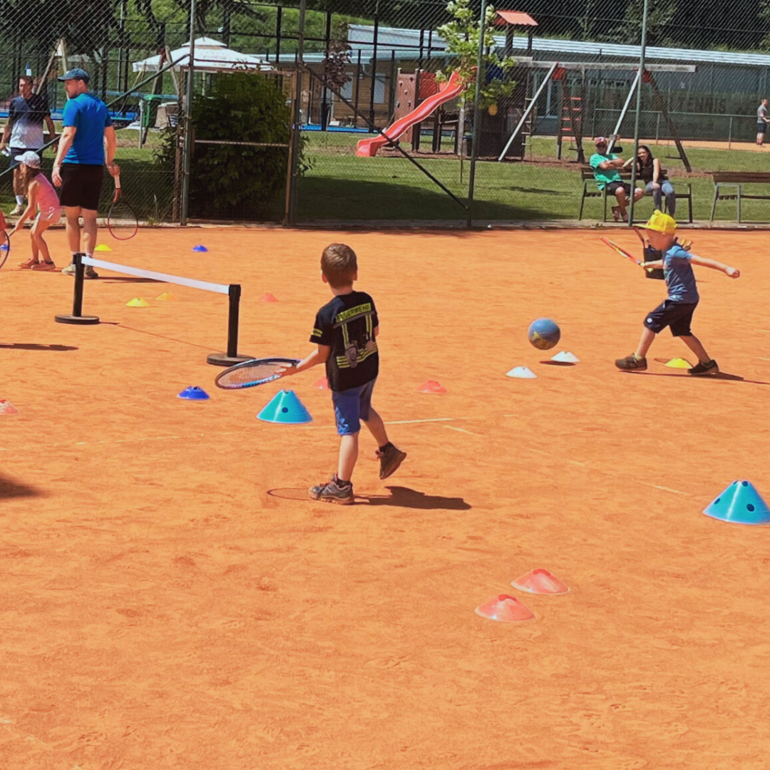 Kindergartenkinder bei Rückschlagspielen mit Mini-Netz, Hütchen und Kinderschlägern